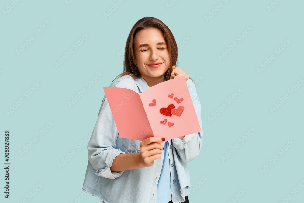 Beautiful young woman holding greeting card with hearts on blue background. Valentine's Day celebration Beautiful young woman holding greeting card with hearts on blue background. Valentine's Day celebration