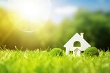 Green home icon on a green lawn with sun shining copy space. Environmentally friendly construction