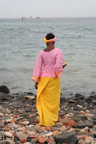 une femme africaine en très belle tenue admirant l'océan photo