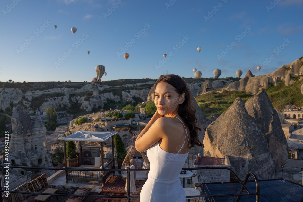 Cappadocia, Asian woman watches the flight of hot air balloons early in the morning in Cappadocia, tourism in Turkey