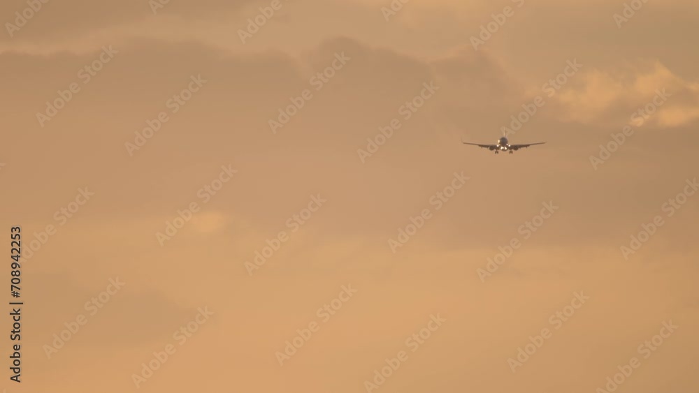 Jet plane approaching to land at bright sunset sky. Unrecognizable airliner in the backlit sky. Cinematic shot of airplane flies, beautiful sunset Jet plane approaching to land at bright sunset sky. Unrecognizable airliner in the backlit sky. Cinematic shot of airplane flies, beautiful sunset