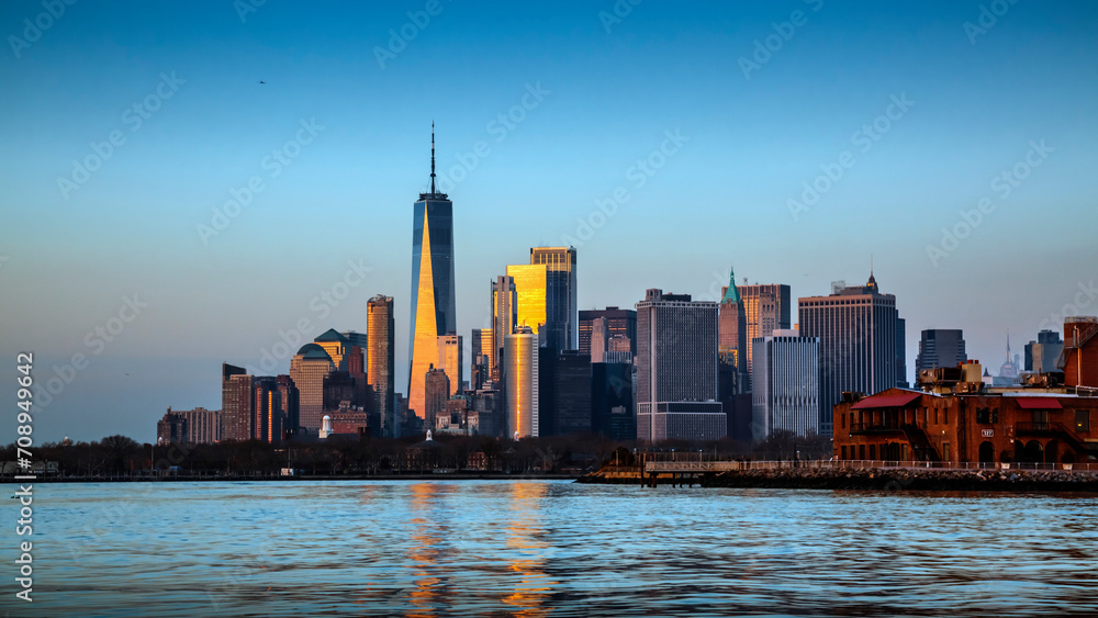 Obraz premium Manhattan from Hudson Bay Brooklyn, at sunset with light reflection in towers, New York