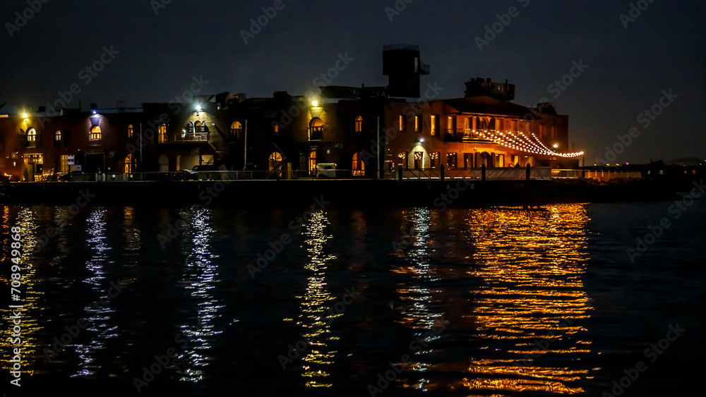 Obraz premium Red Hook old pier buildings with night lights and reflection in water, Brooklyn, New York