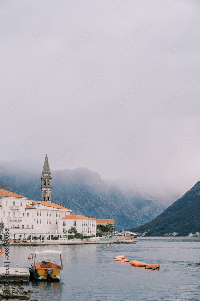 Motorboat is moored off the coast of Perast against the backdrop of mountains in dense fog. Montenegro