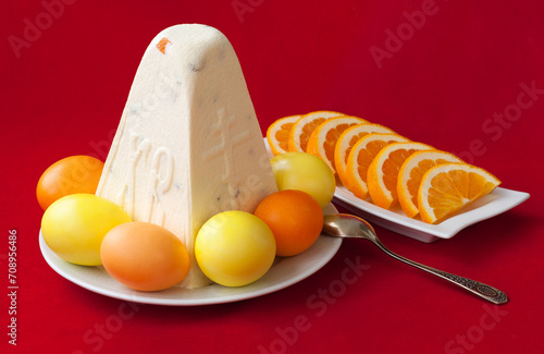 Traditional Easter cottage cheese dessert Paskha with eggs and oranges on red background. Modern minimalistic Easter background with copy space for your design. photo