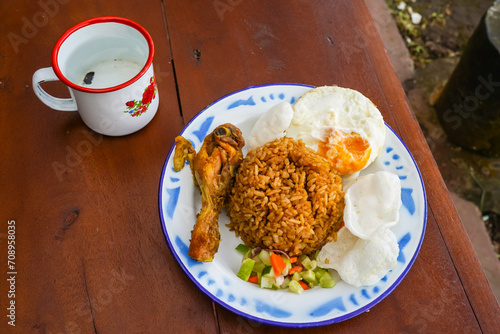 Javanese village style fried rice, with fried egg, crackers and chopped vegetables
