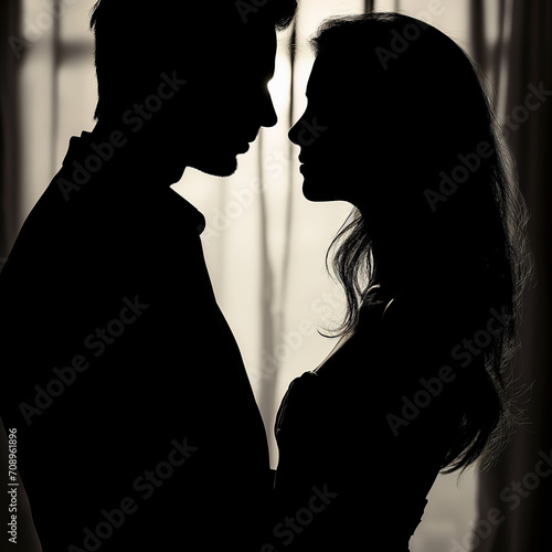 Silhouette of a couple in a romantic but secretive embrace. Concept of affairs and adultery.
