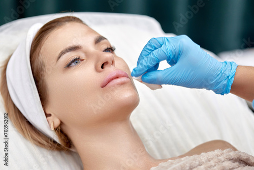 woman receives cosmetic injection in lips. Woman in beauty salon.