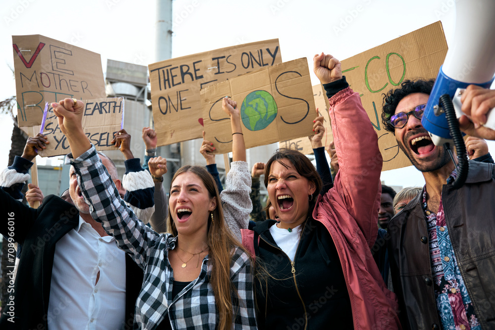 Serious girl with her fist in the air in a demonstration. Group of ...
