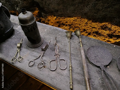 Various medieval instruments for lighting in cellars, bell shaped candle extinguishers with handle, scissors for candlewick adjustment, plates and lantern for candle transport. 