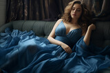 Elegant woman lounging on a couch, draped in a luxurious satin blue gown, with a moody ambiance