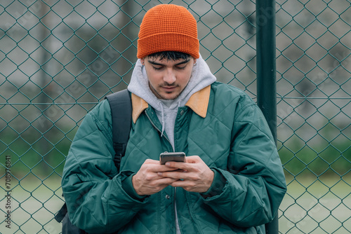 young man in winter on the street with mobile phone photo