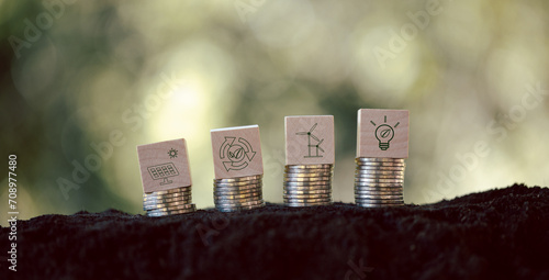Green energy icons on wooden cubes with stack money coin. Green business growth. Finance sustainable development. growing money, finance and investment. Alternative sources of energy. Eco business photo
