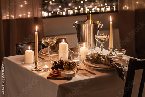 holidays, romantic date and celebration concept - close up of festive table serving for two with champagne bottle in ice bucket and candles burning at home on valentine's day photo