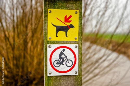 Montfoort, The Netherlands, January 13, 2024: signs on a hiking trail indicating no entry for bicycles and dogs to be kept on a leash photo