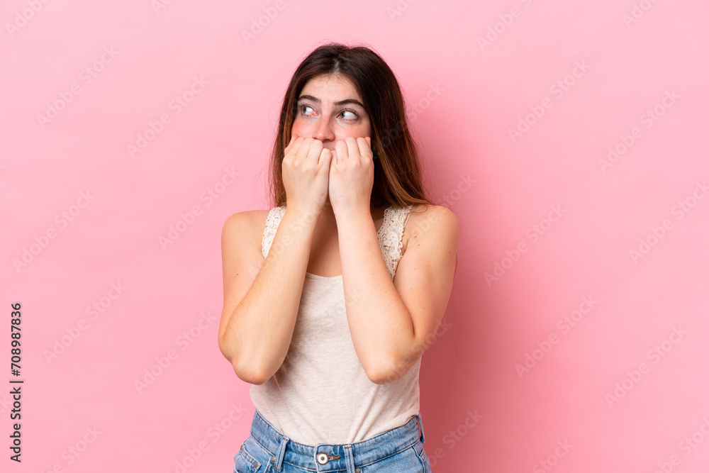 Young caucasian woman isolated on pink background nervous and scared putting hands to mouth Young caucasian woman isolated on pink background nervous and scared putting hands to mouth