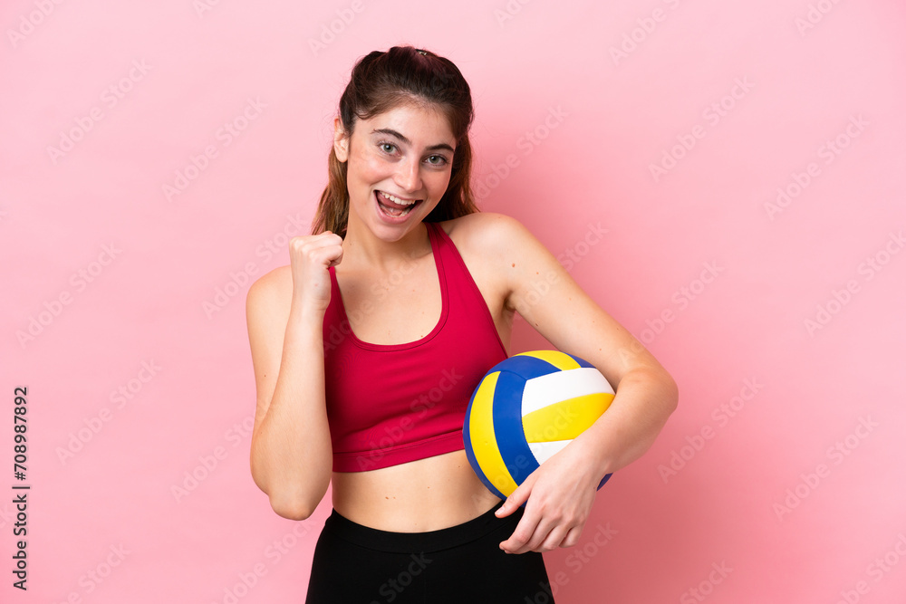 Young caucasian woman playing volleyball isolated on pink background celebrating a victory in winner position Young caucasian woman playing volleyball isolated on pink background celebrating a victory in winner position