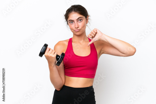 Young sport caucasian woman making weightlifting isolated on white background showing thumb down with negative expression