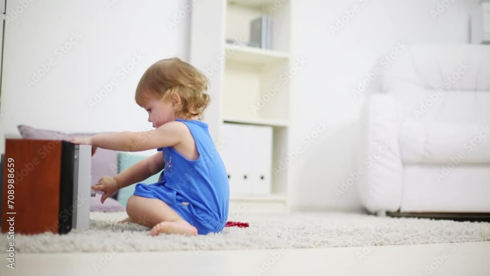 Little cute girl presses button on music system in room at home Little cute girl presses button on music system in room at home