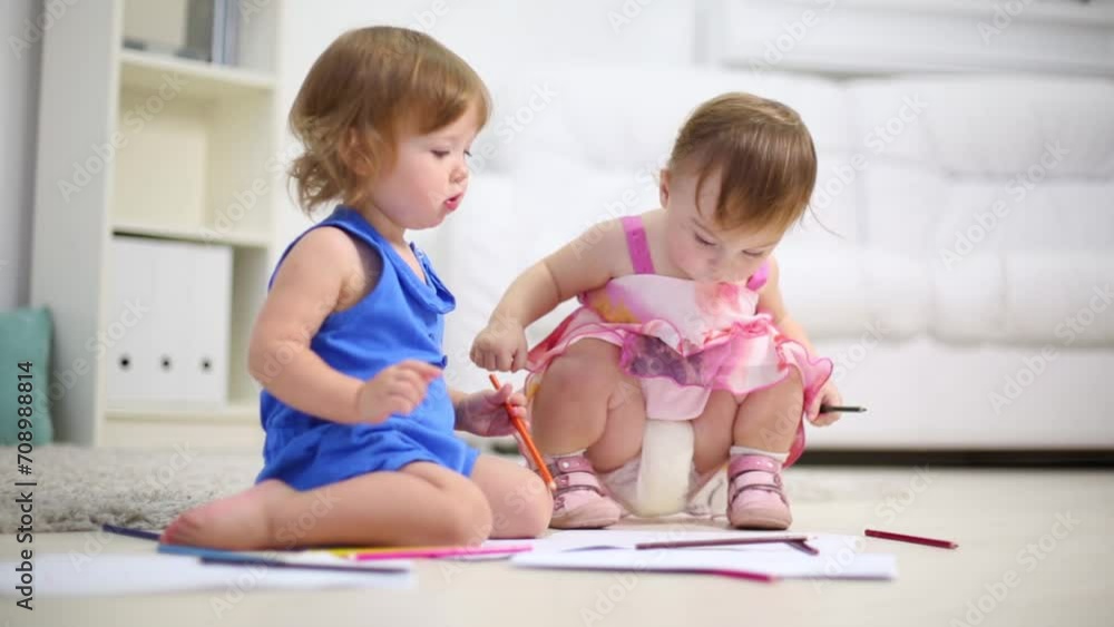 Two little kids draw by pencils on floor in room at home Two little kids draw by pencils on floor in room at home