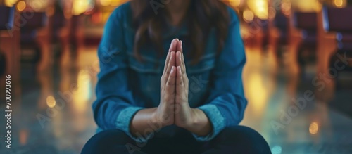 Female hands in prayer position in church, showing humility, faith in God, seeking guidance, and strength through devotion to religion, in accordance with the teachings of Jesus Christ.