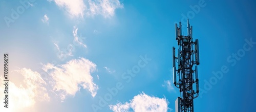 4G and 5G cellular tower with antennas against blue sky. photo
