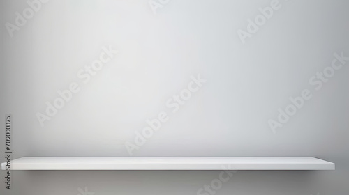 White empty shelf on a light gray wall.A simple white shelf with a soft light illuminating it, perfect for showcasing products or creating a cozy atmosphere in interior design and home decor concepts. photo