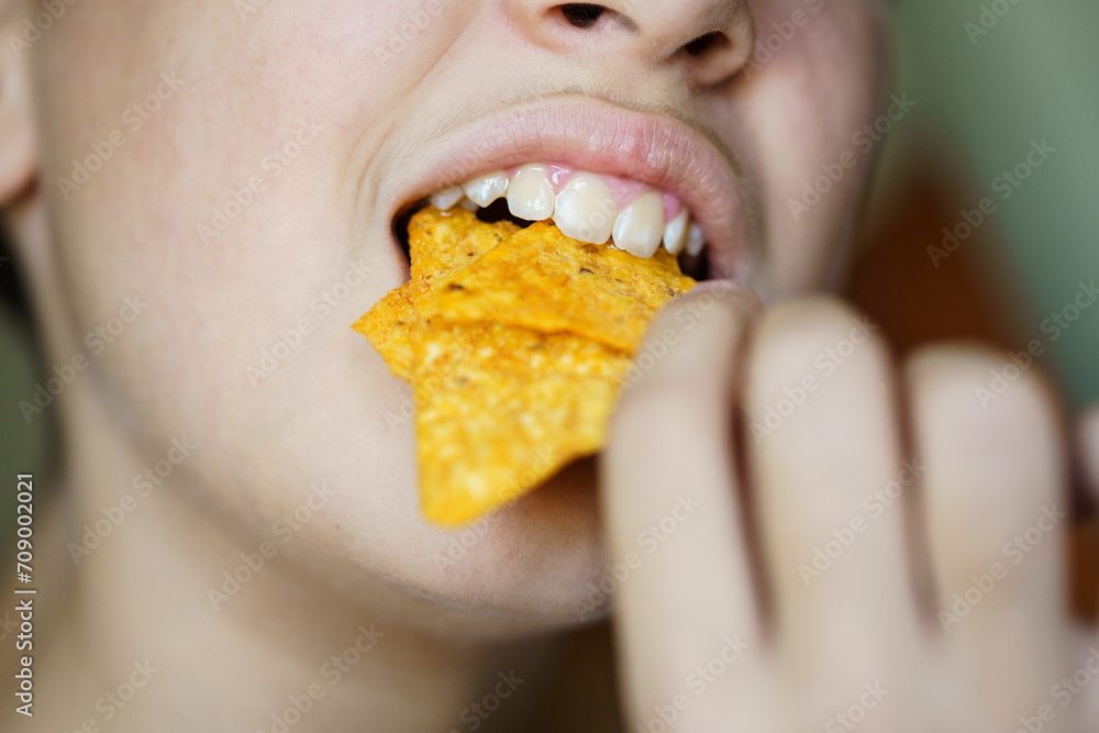 Crop anonymous girl biting yummy crunchy Mexican tortilla chips Crop anonymous girl biting yummy crunchy Mexican tortilla chips