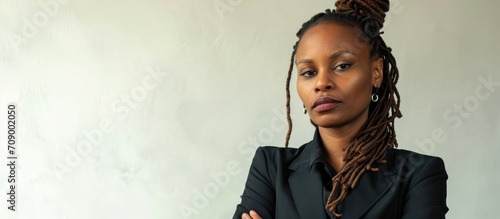 African American woman with braided hair wearing business attire, appearing skeptical and disapproving with crossed arms and a negative expression. photo