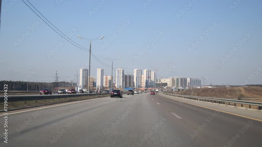 Many cars fast go on highway to big city at summer day Many cars fast go on highway to big city at summer day