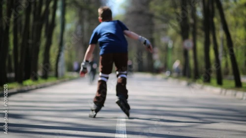 Wallpaper Mural Back of boy riding on roller skates in summer park. Torontodigital.ca
