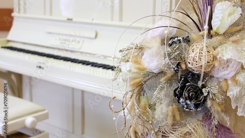 White old beautiful piano and bouquet of artificial flowers. photo
