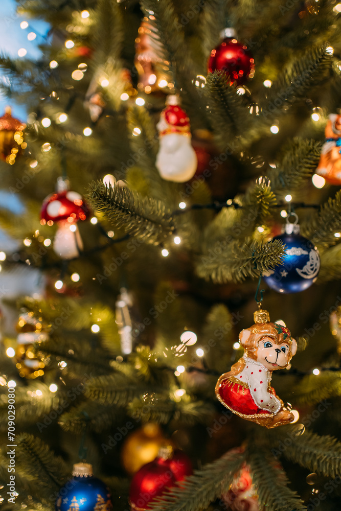 Christmas toys on an artificial Christmas tree. A toy in the form of a monkey figurine is a symbol of the lunar calendar year