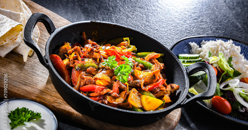 Fajita with peppers and onions served on a hot iron skillet