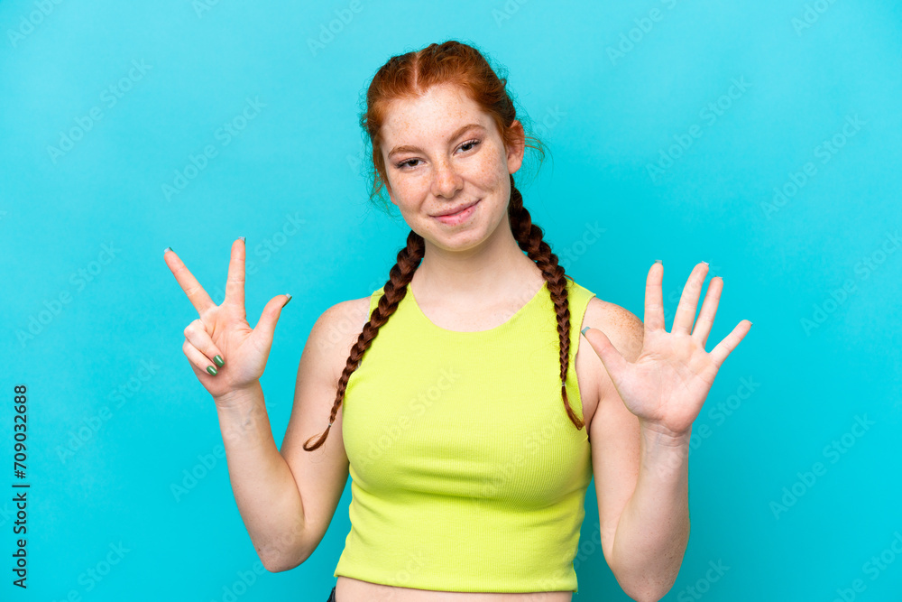 Young reddish woman isolated on blue background counting eight with fingers Young reddish woman isolated on blue background counting eight with fingers