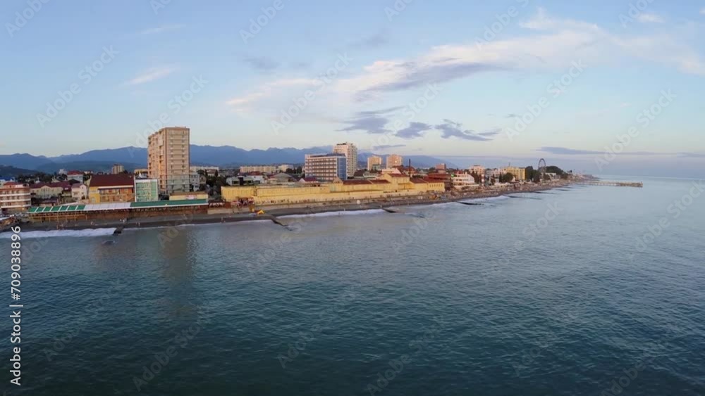 Coastal town near mountains during sunset. Aerial view Coastal town near mountains during sunset. Aerial view