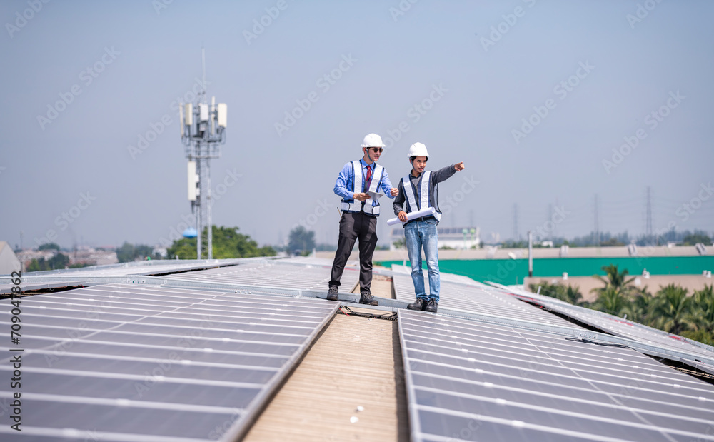 Engineers walking on roof inspect and check solar cell panel by hold equipment box and radio communication ,solar cell is smart grid ecology energy sunlight alternative power factory concept	