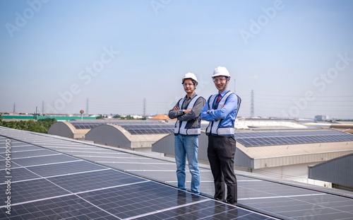 Engineers walking on roof inspect and check solar cell panel by hold equipment box and radio communication ,solar cell is smart grid ecology energy sunlight alternative power factory concept 