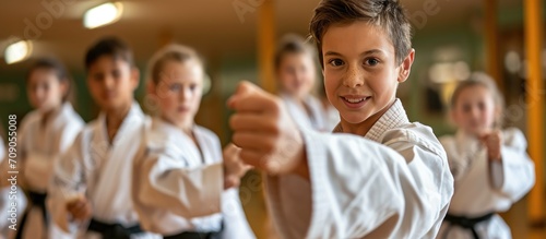 Preteens practicing karate with male coach in class.