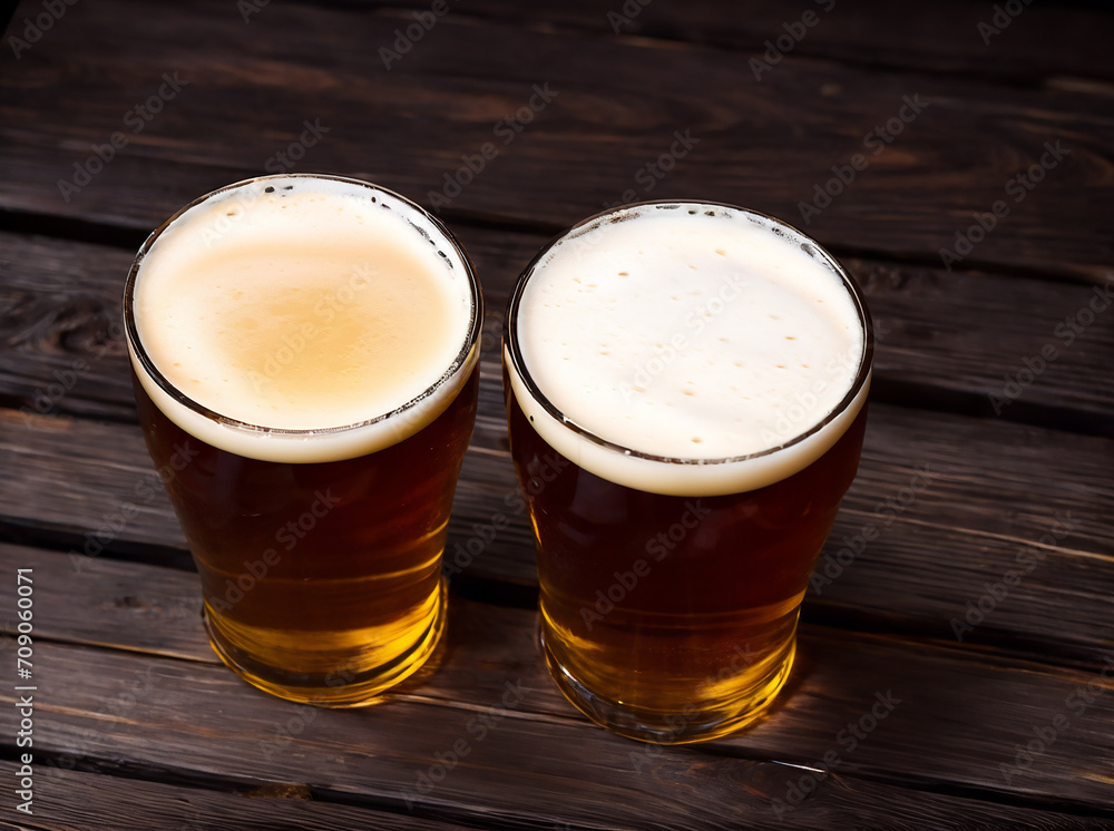 Two glasses of beer on a dark wooden background, viewed from above, with space for text 