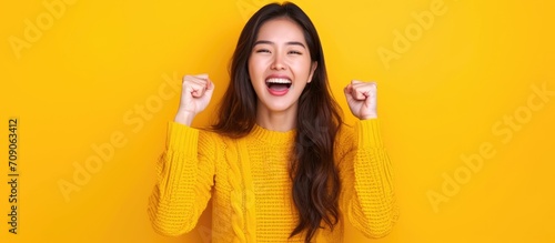 Joyful Asian woman celebrating an online victory, happy about positive news, motivated by success and new opportunity. photo