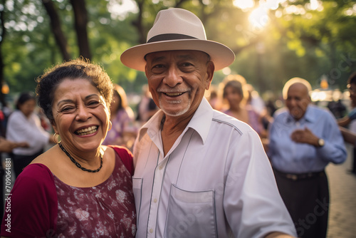 Older Hispanic couple enjoy dancing together in a public park in the city