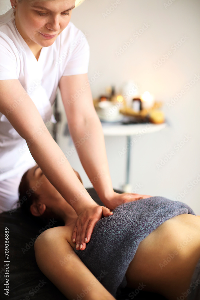 Crop masseur massaging body of woman