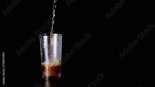 Wallpaper Mural Pouring Hot Tea, Drink, or Whiskey into a Wet Glass on a Black Background. Close up. Stream of hot boiling water pouring. Texture. Isolated. Foam with bubbles flows out of a transparent cup. Torontodigital.ca