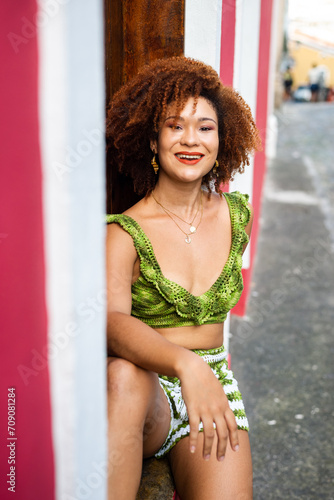 Portrait of a woman with red hair leaning against a wooden window.