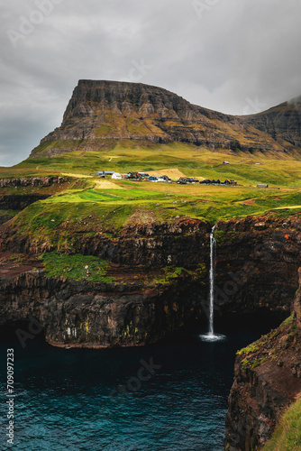 Fototapeta Naklejka Na Ścianę i Meble -  mulafossur waterfall at faroe islands on a cloudy day by atlantic ocean