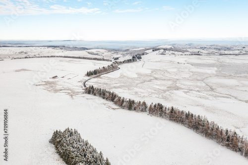 Aerial view of snowy fields with tree and road covered with ice in winter