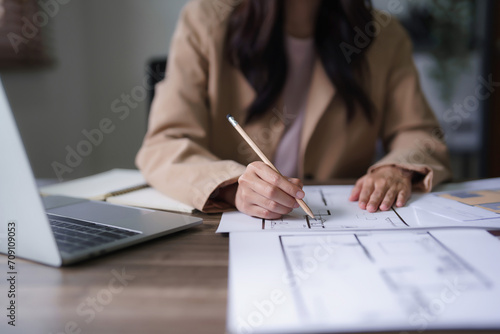 Female architect work to designing interior building and drawing construction project on blueprint