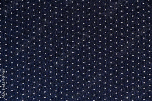 abstract background of dark blue and white polka dot knit fabric texture close up