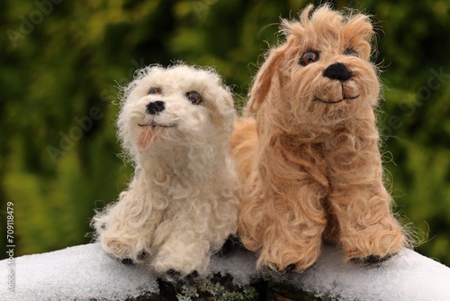 Zwei nadelgefilzte Goldendoodle aus Hundehaaren im Schnee.